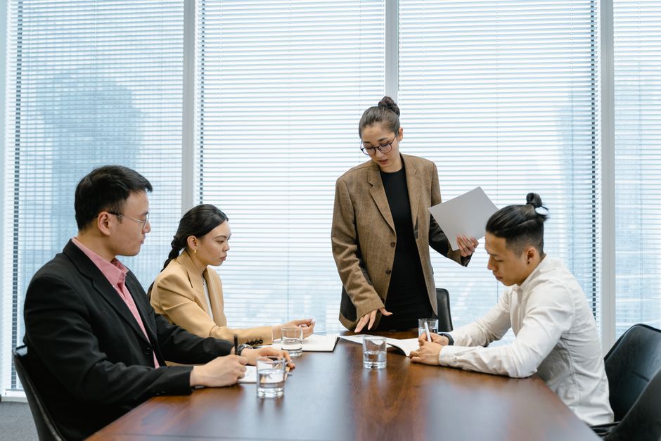 会議室で資料を手に提案し、説明を行う様子